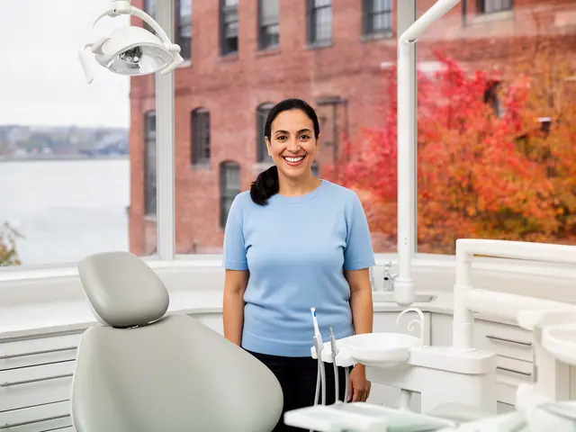 A dentist standing beside a dental chair.